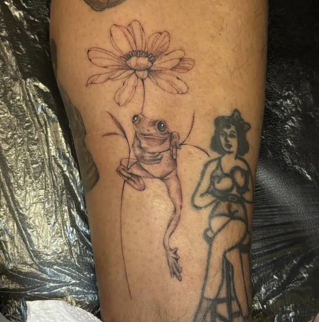 Bloem met kikker en pin-up op de arm